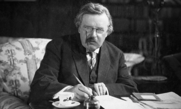 G.K. Chesterton writing at his desk